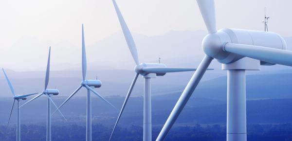 A row of white wind turbines with a sunset background